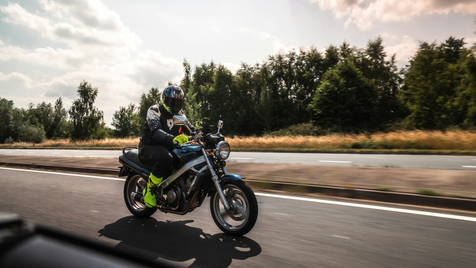A motorcyclist riding a two-lane road